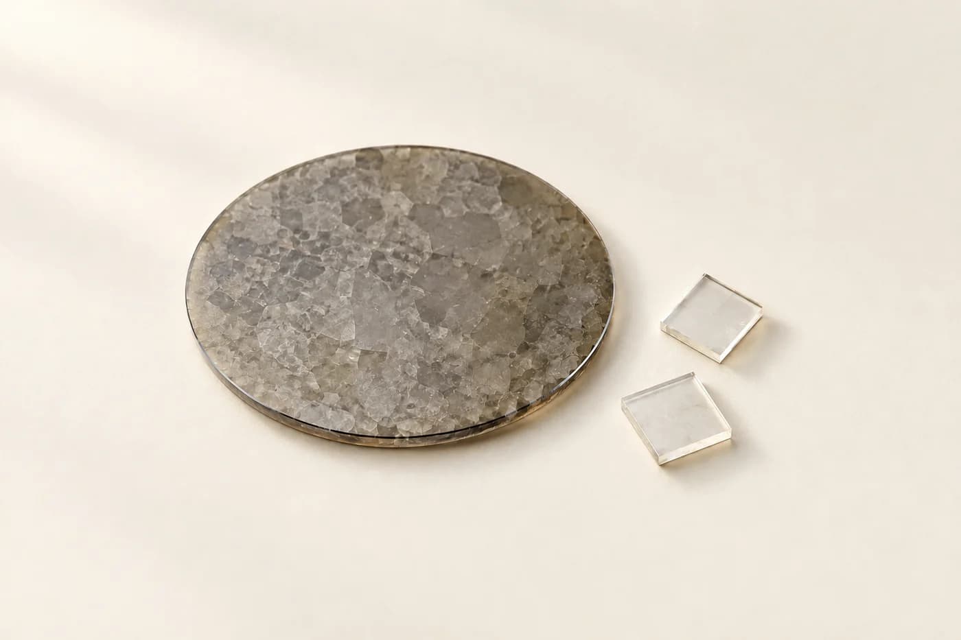 Thin diamond wafer with two clear square diamond plates on an ivory surface
